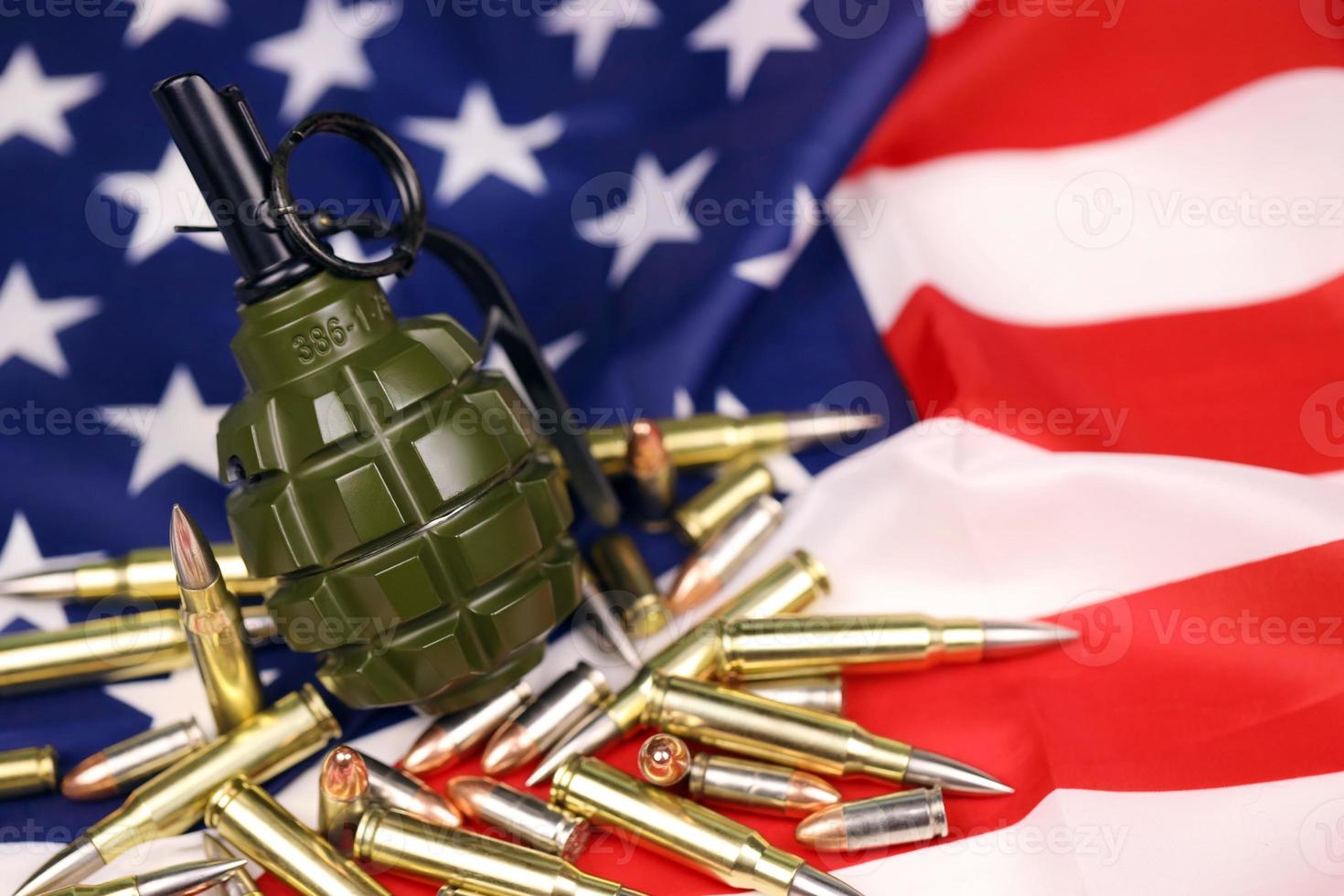 F1 frag grenade and many yellow bullets and cartridges on United States flag. Concept of gun trafficking on USA territory or spec ops photo