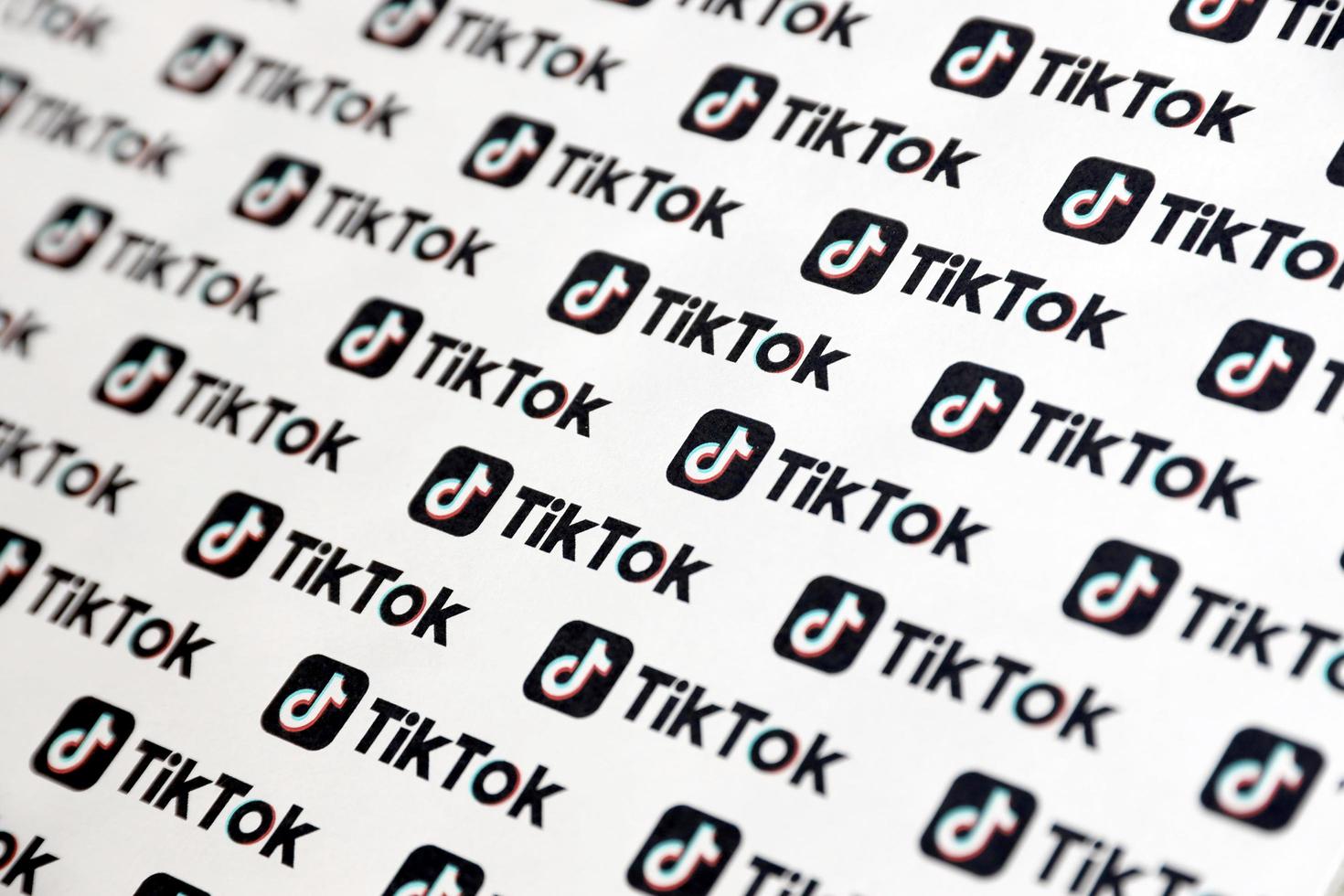 TERNOPIL, UKRAINE - MAY 2, 2022 Many TikTok logo printed on paper. Tiktok or Douyin is a famous Chinese short-form video hosting service owned by ByteDance photo