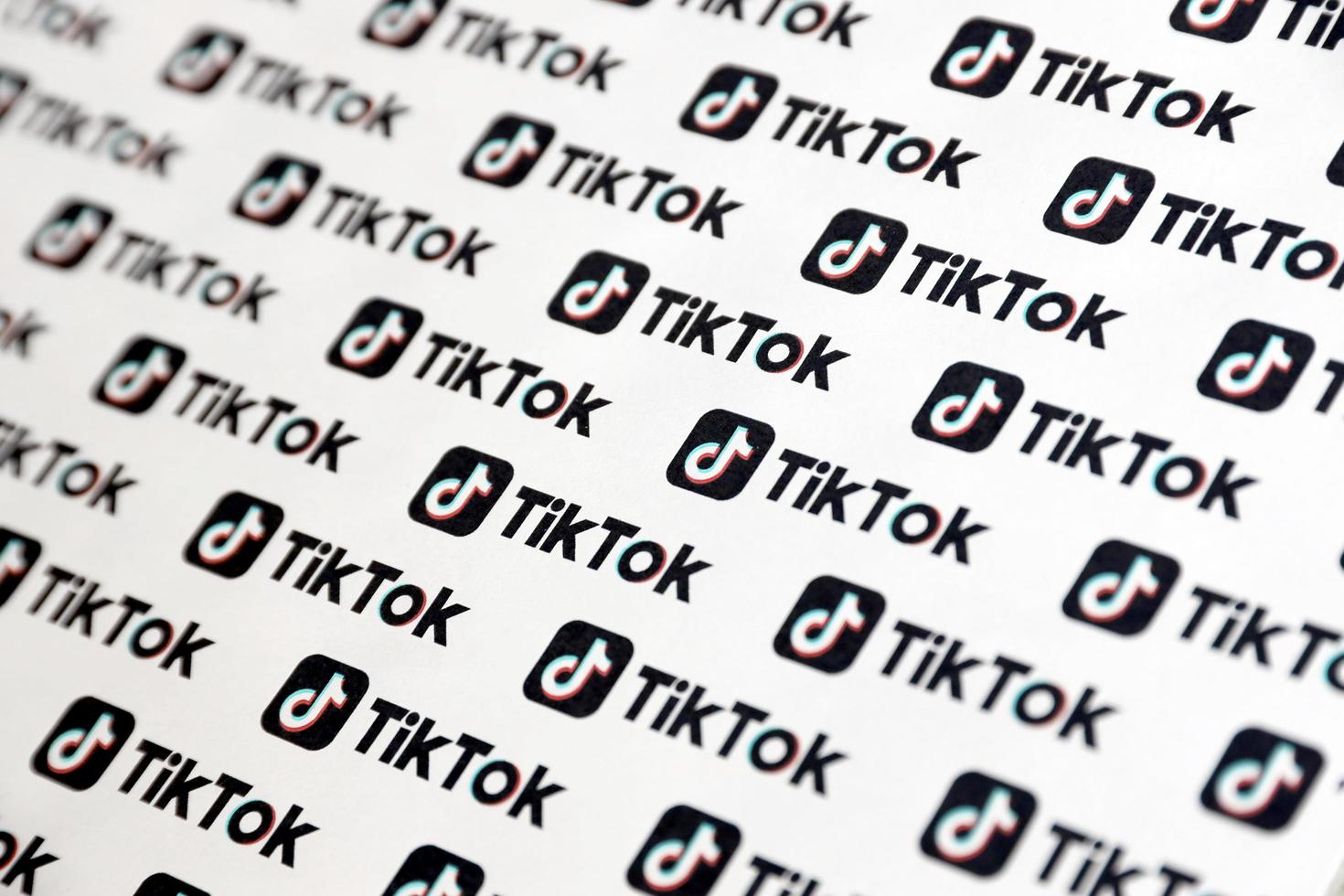 ternopil, ucrania - 2 de mayo de 2022 muchos logotipos de tiktok impresos en papel. tiktok o douyin es un famoso servicio chino de alojamiento de videos de formato corto propiedad de bytedance foto