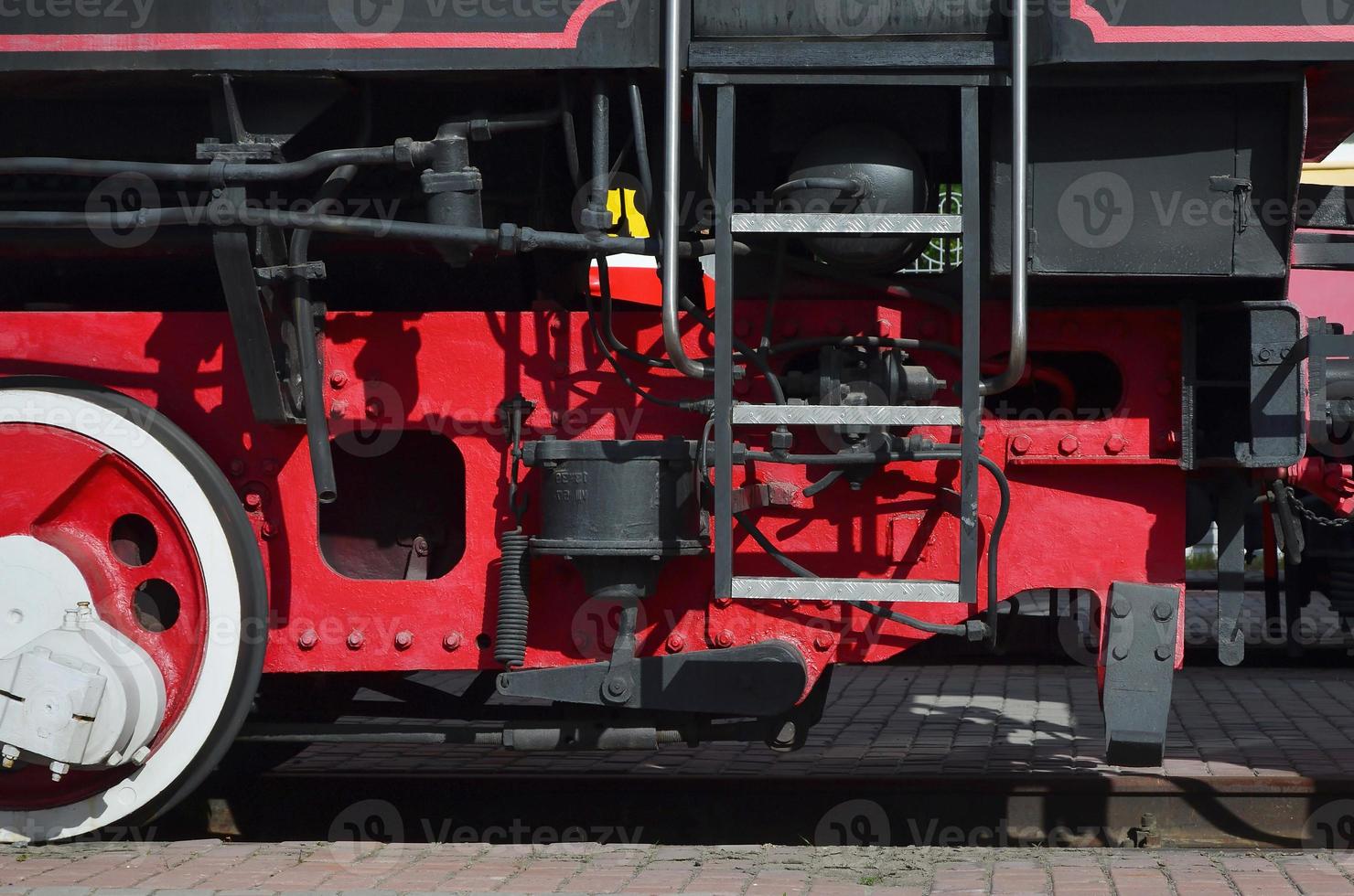 Wheels of the old black steam locomotive of Soviet times. The side of the locomotive with elements of the rotating technology of old trains photo