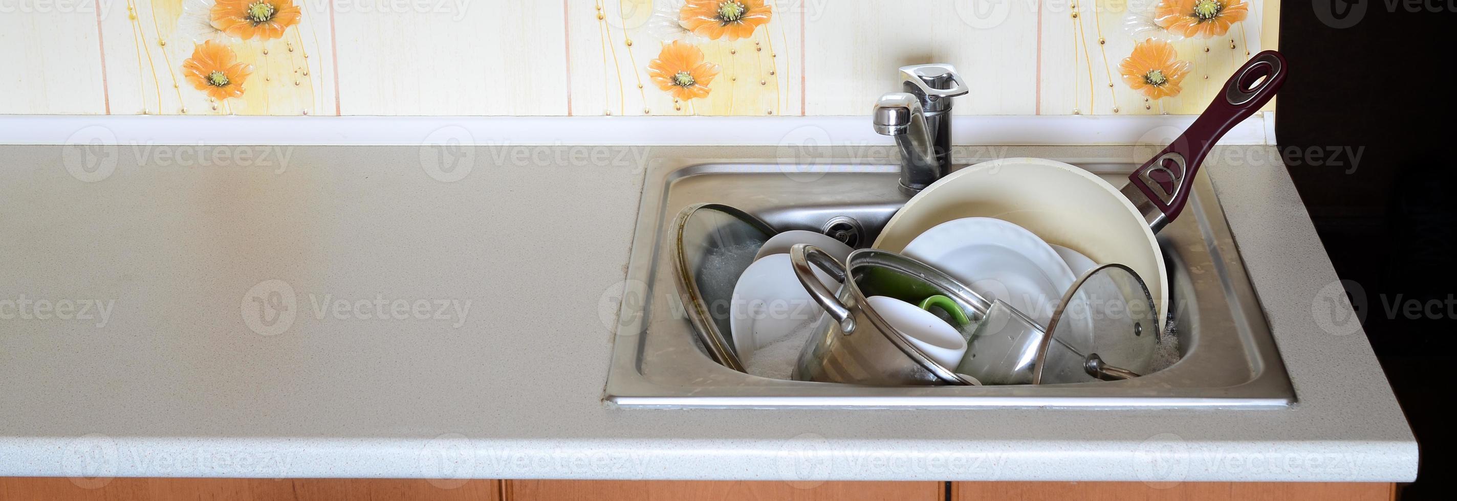 Dirty dishes and unwashed kitchen appliances filled the kitchen sink photo