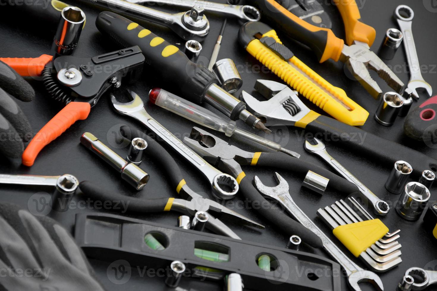 Handyman tool kit on black wooden table. Many wrenches and