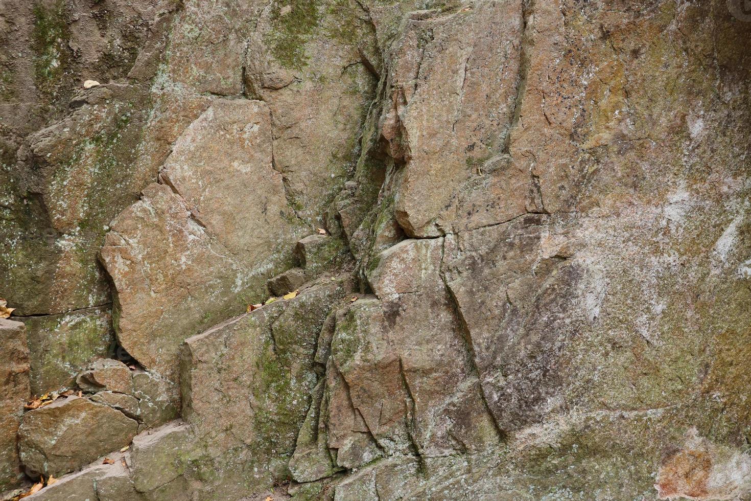 Light coarse natural rock stone background. Mining cliff rough front surface. Big limestone stack backdrop. Heavy grunge damaged granite block texture photo