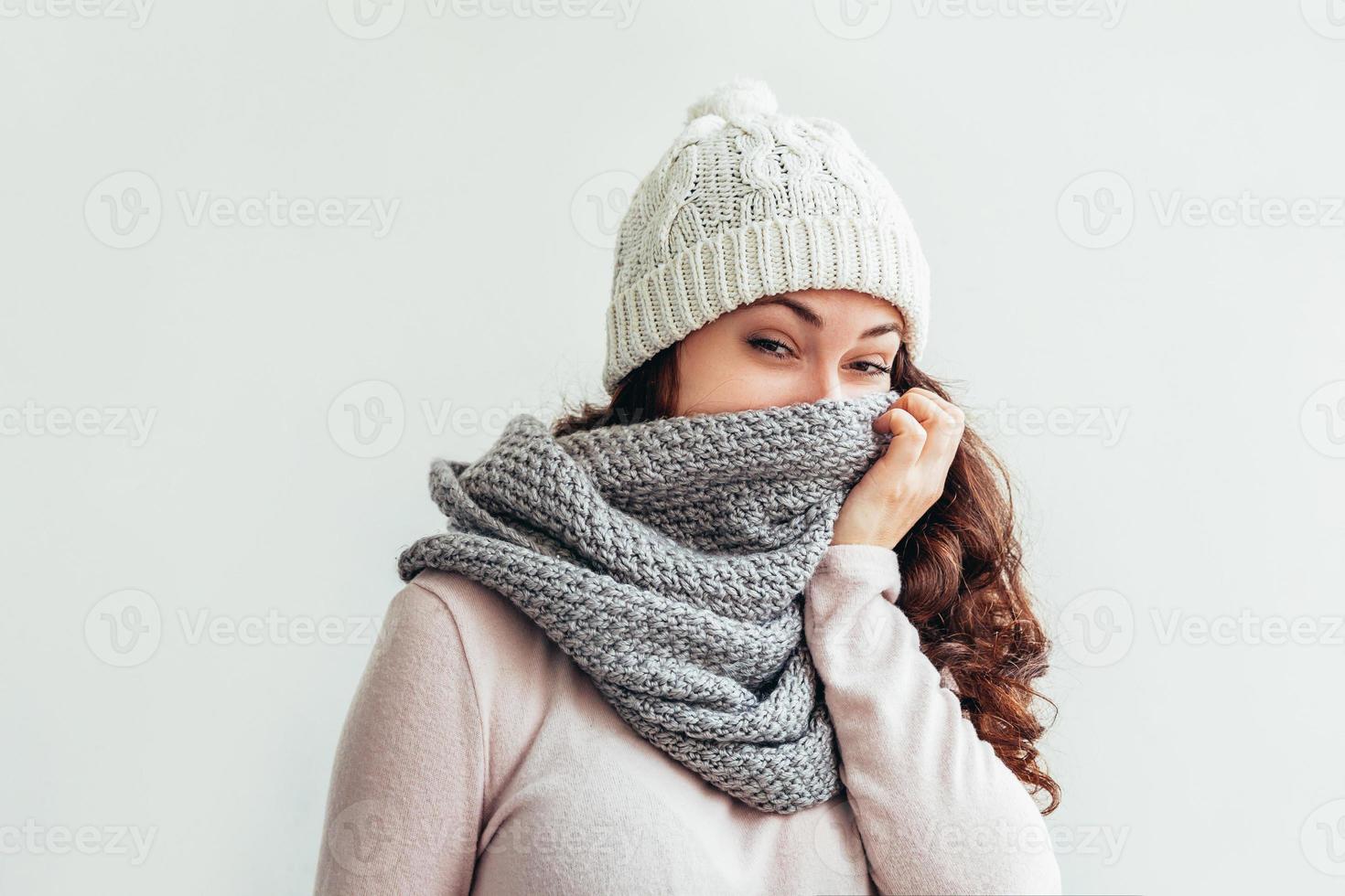 Laughing girl wearing warm clothes hat and scarf isolated on white background photo