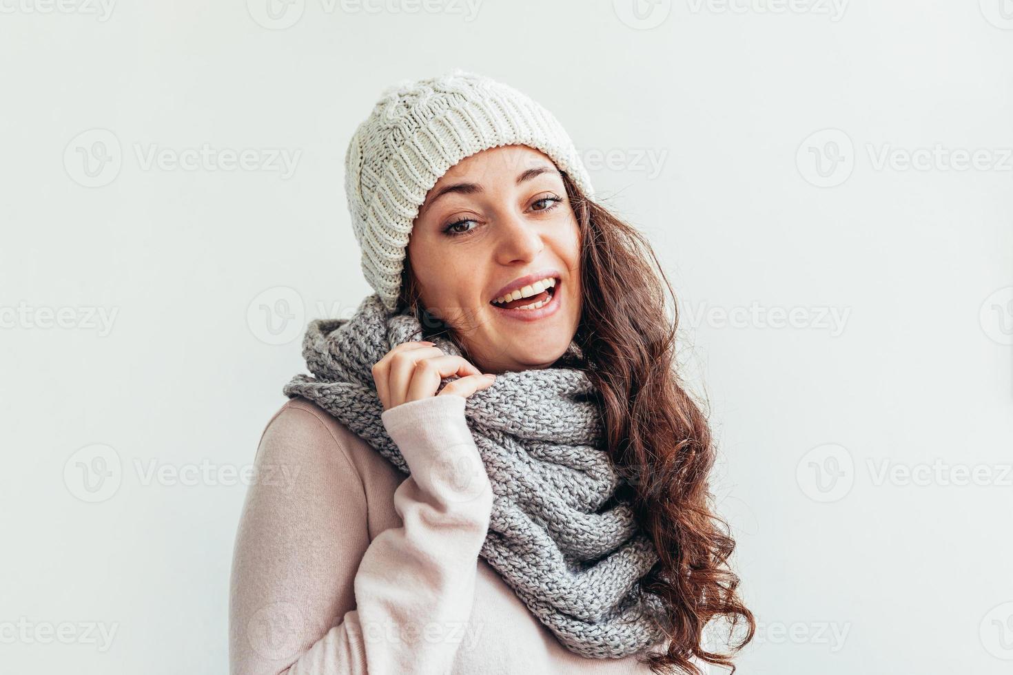 Chica riendo vistiendo ropa de abrigo sombrero y bufanda aislado sobre fondo blanco. foto