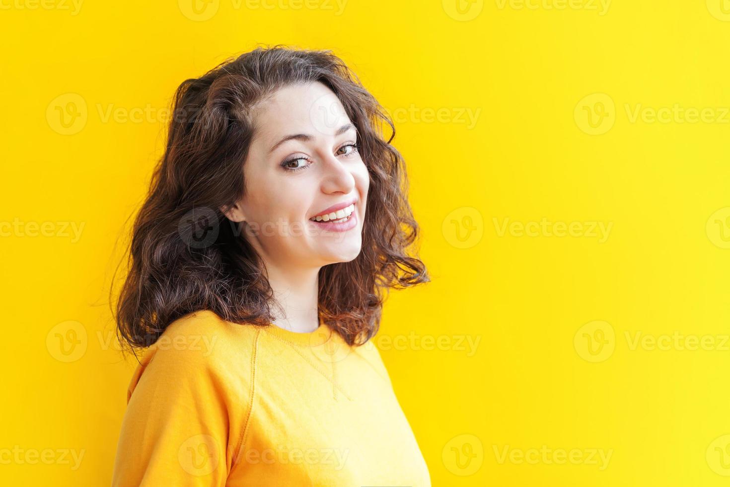 Happy girl smiling. Beauty portrait young happy positive laughing brunette woman on yellow background isolated. European woman. Positive human emotion facial expression body language photo