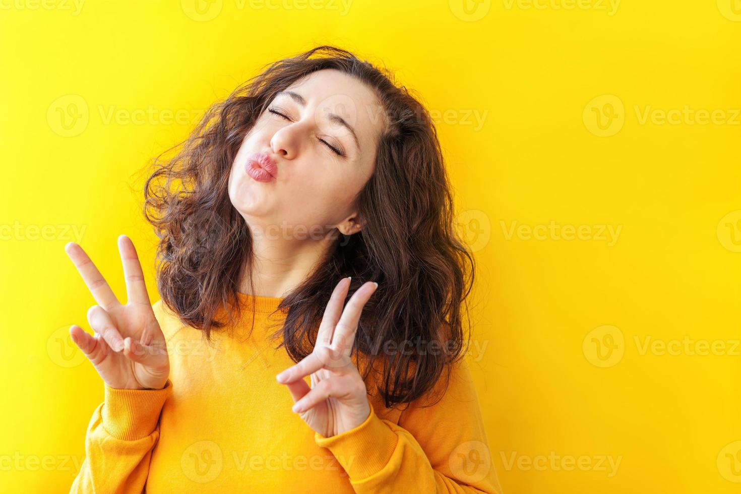 Young woman posing over yellow background. Emotional female portrait. Hipster  girl. Stock Photo