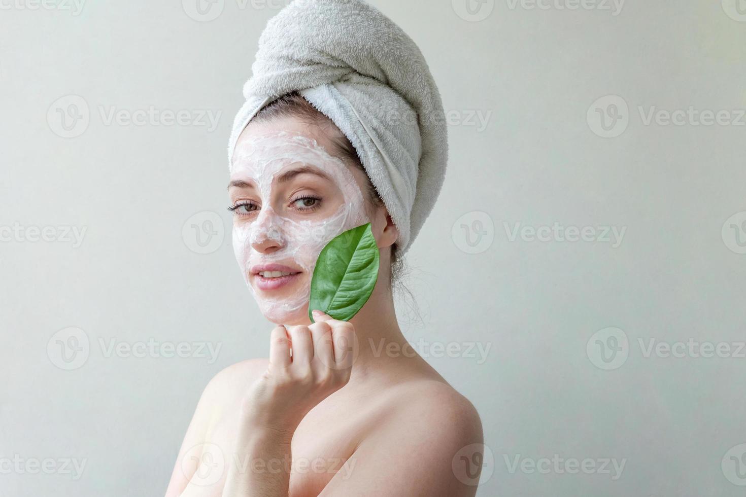 cara de mujer con hoja verde y crema o mascarilla nutritiva foto