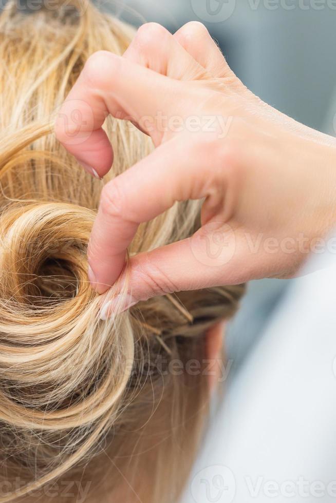 Hairstylist making bride wedding hairstyle photo