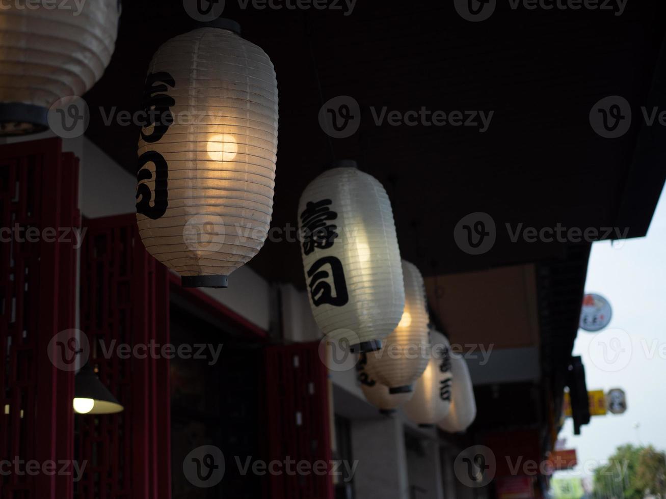 linterna japonesa colgada frente al restaurante japonés, el texto japonés en la linterna es comida japonesa de sushi. foto