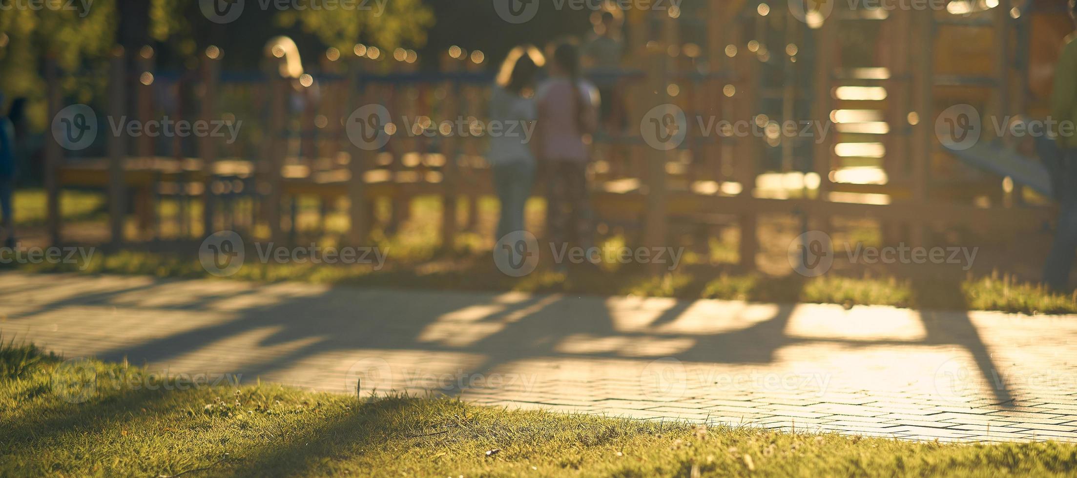 desenfoque de juegos con niños de la brillante luz del sol en el fondo abstracto del parque. efecto de tono de película. foto