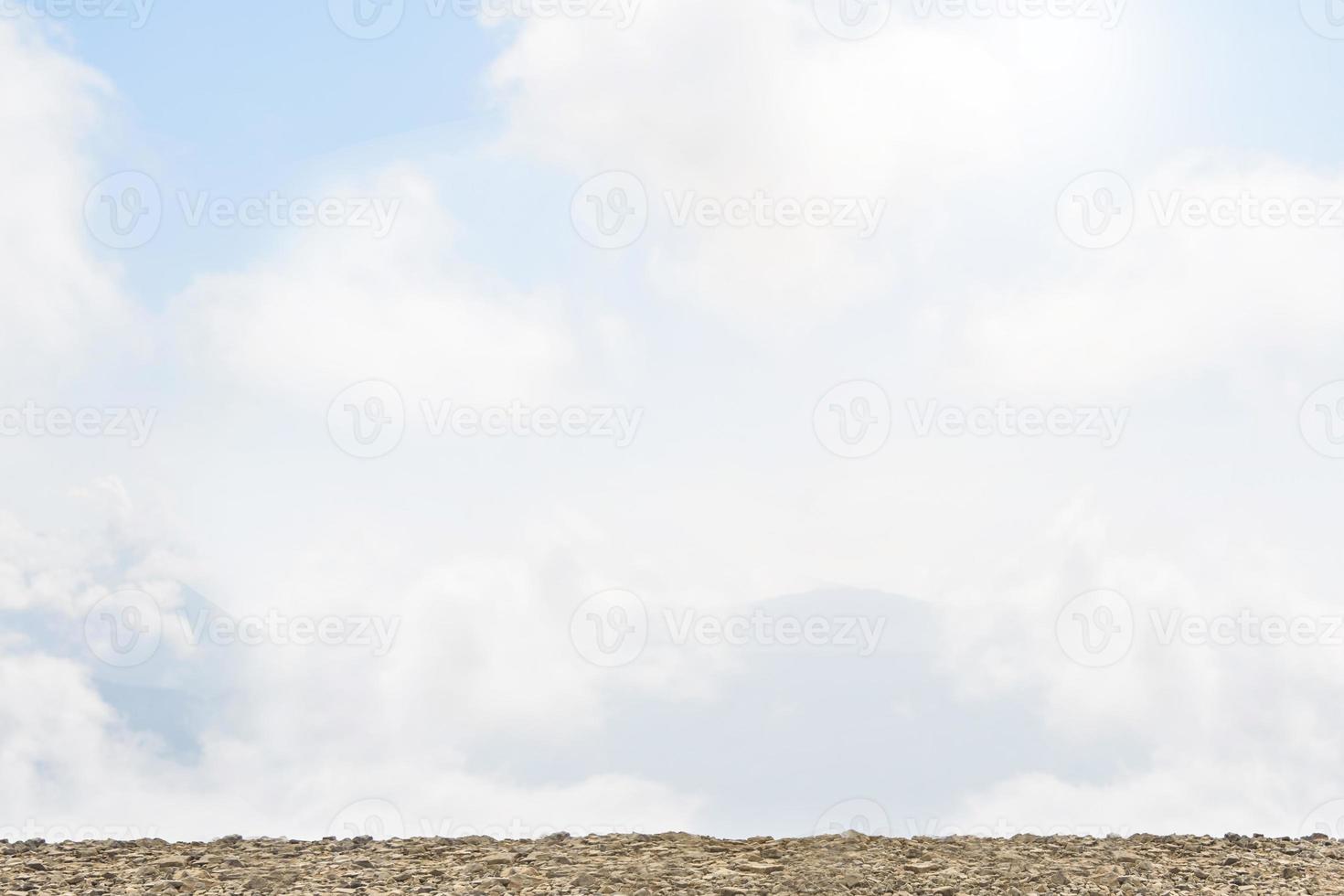 Grey stone table top with blurred blue sky at background, Mock up template for display or montage of your product, Summer holiday concept. photo