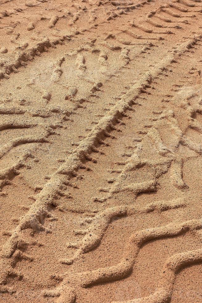 Tyre tracks on sand in brown tone. Abstract background and pattern. photo