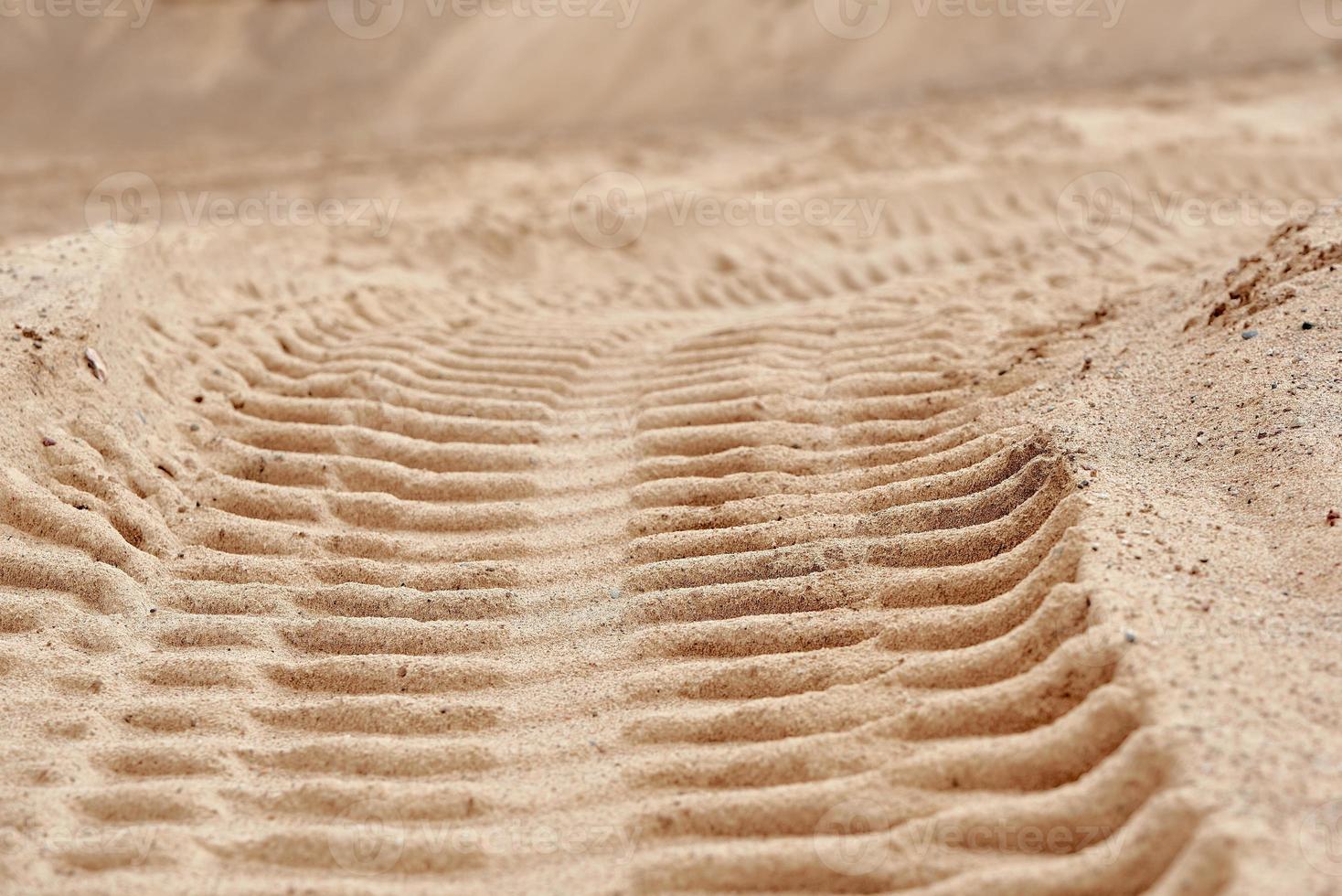 Traces of tread construction equipment on the sand. photo