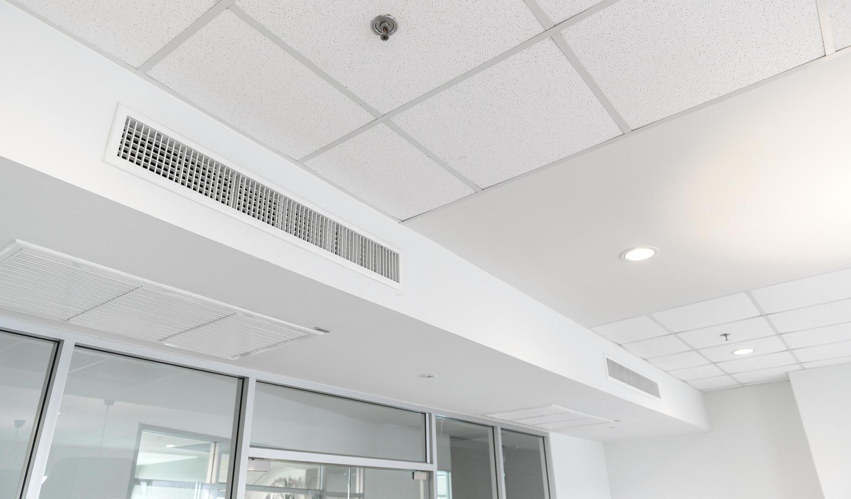 Ceiling mounted cassette type air conditioner and modern lamp light on white ceiling. duct air conditioner for home or office photo