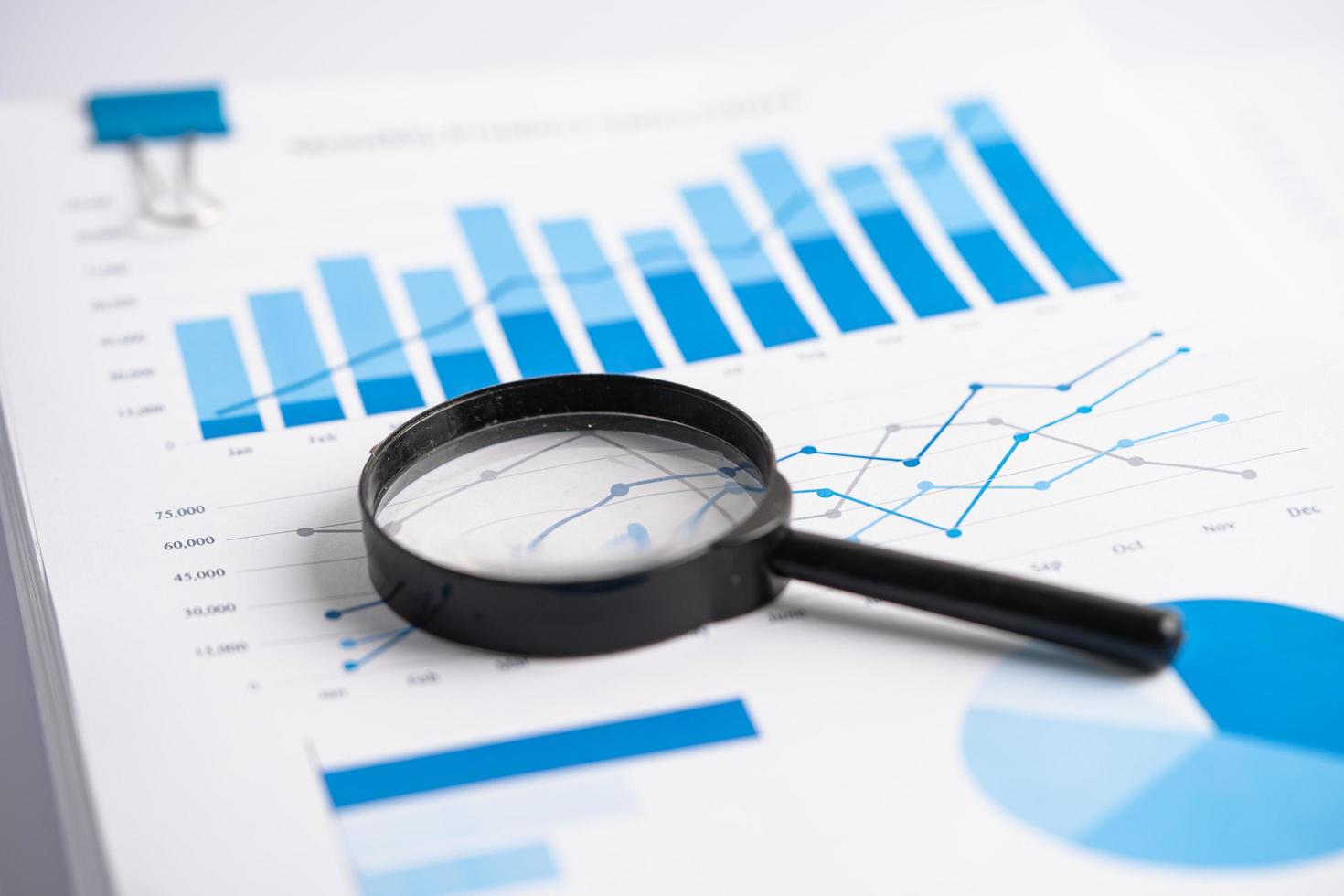 Magnifying glass on charts graphs paper. Financial development, Banking Account, Statistics, Investment Analytic research data economy, Stock exchange trading, Business office company meeting concept. photo