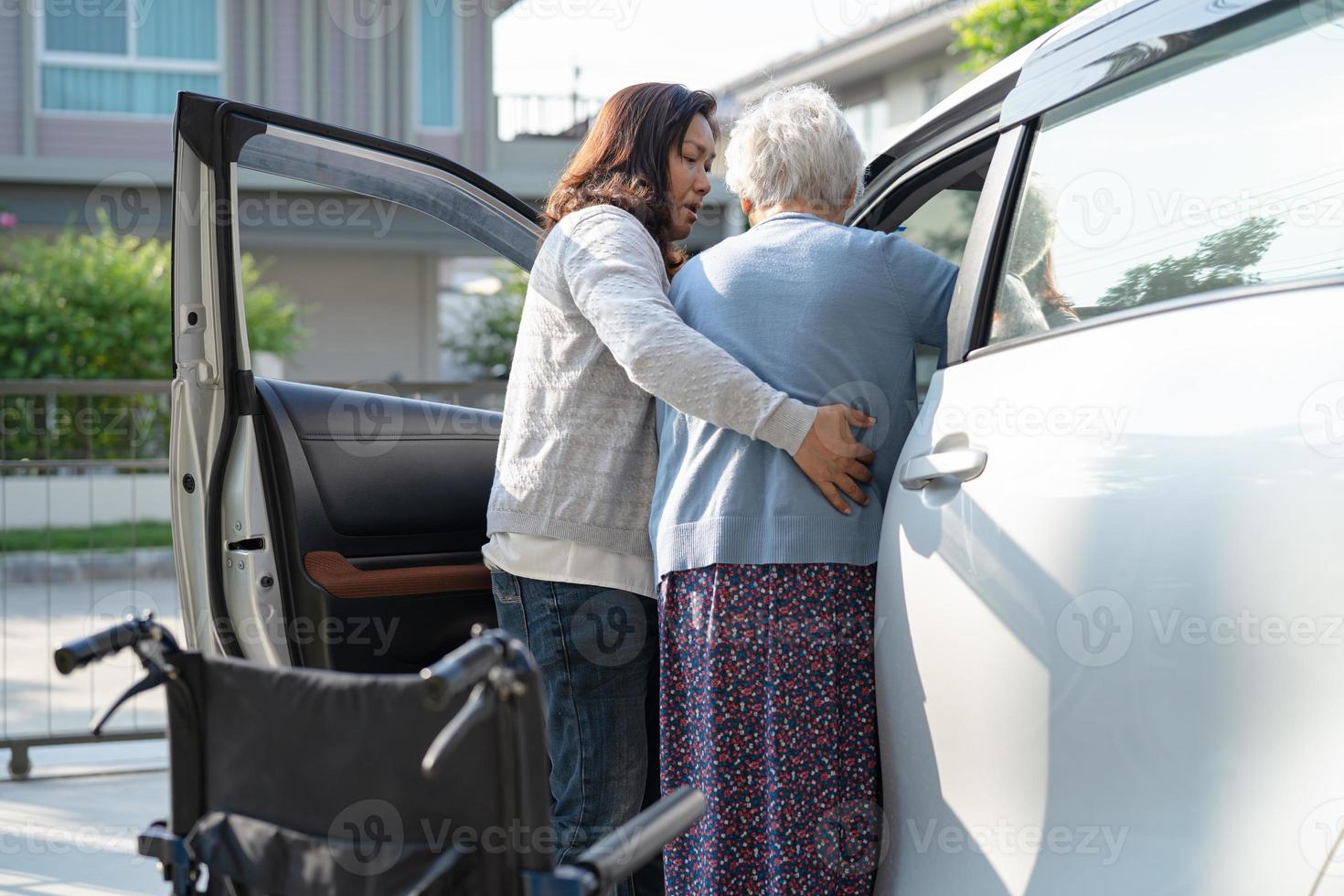 Asian senior or elderly old lady woman patient sitting on wheelchair prepare get to her car, healthy strong medical concept. photo