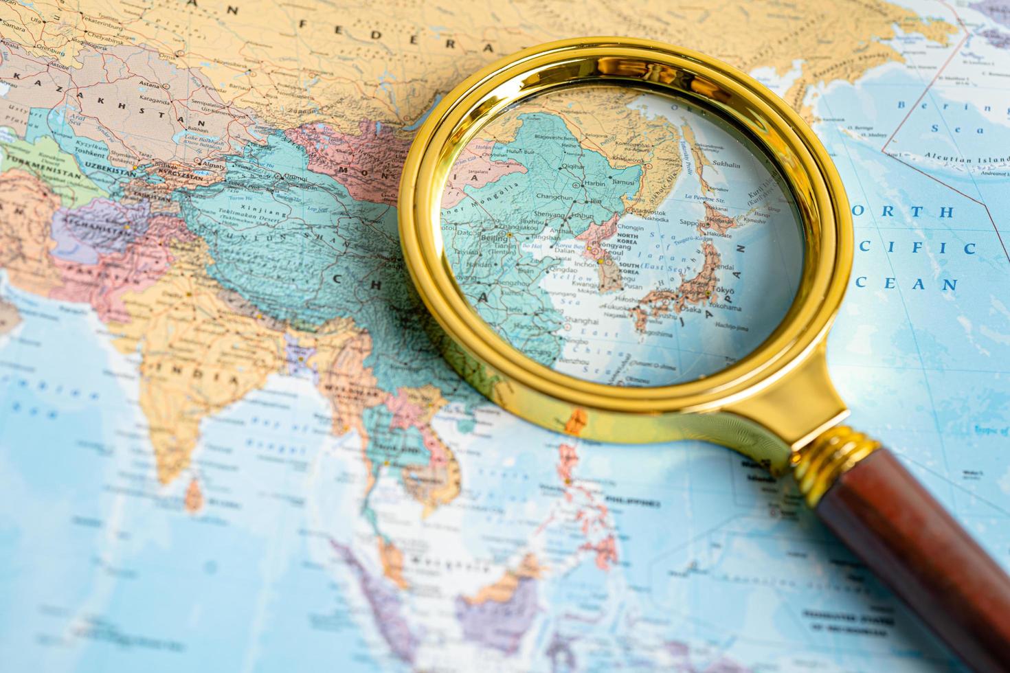 Bangkok, Thailand - August 01, 2022 Japan, Magnifying glass close up with colorful world map photo