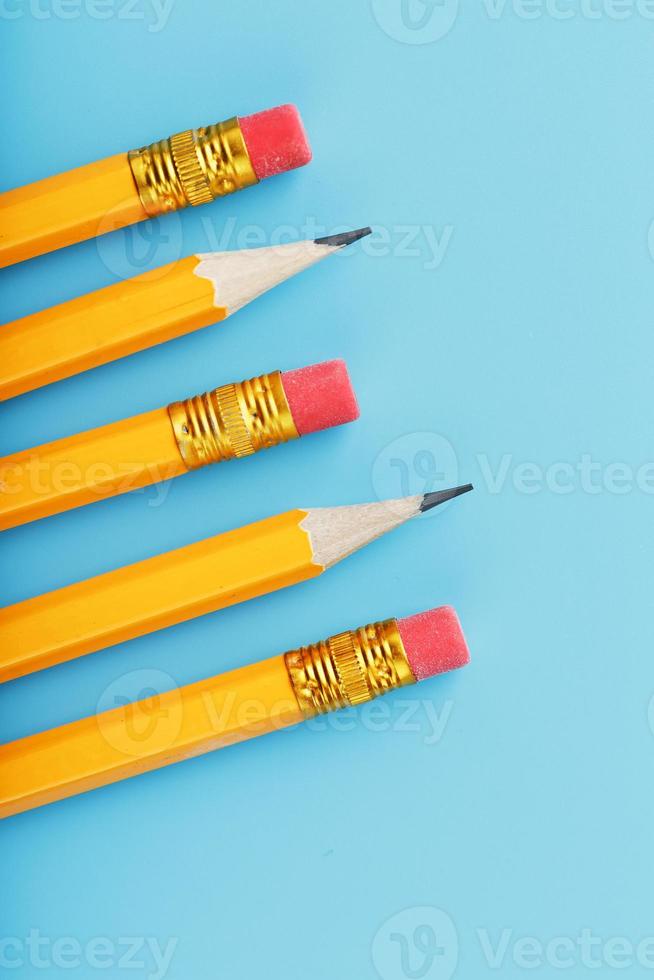 Orange pencils with an eraser on a blue background. photo