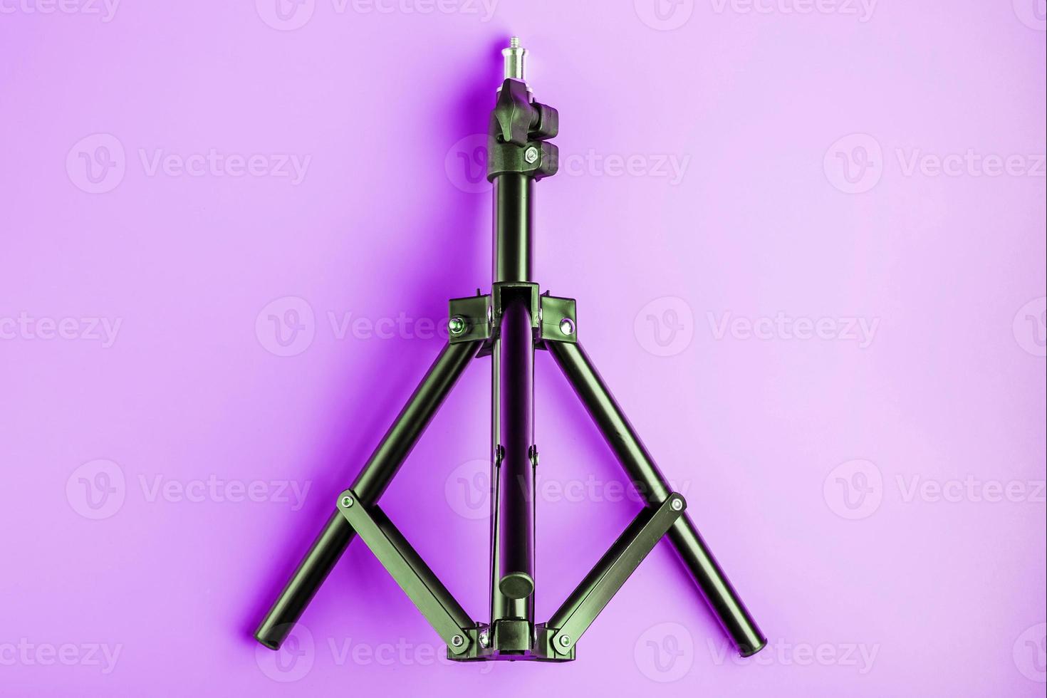 Tripod on pink background for photo-video camera and flash. Free space photo