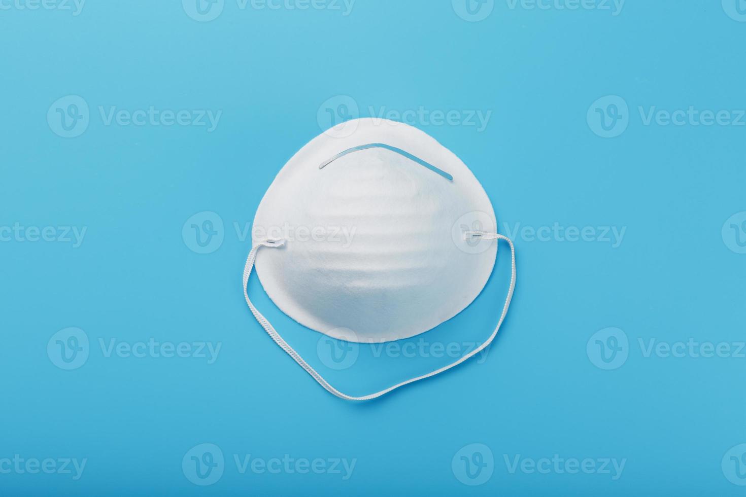 máscara de cara redonda sobre un fondo azul. aislamiento de protección antivirus foto