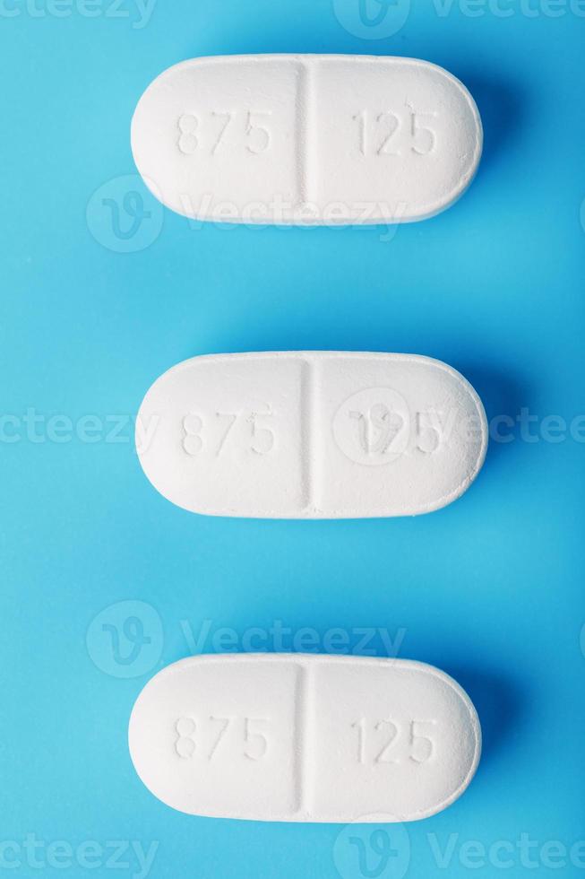 Medicinal tablets in a row on a blue background, isolate. photo
