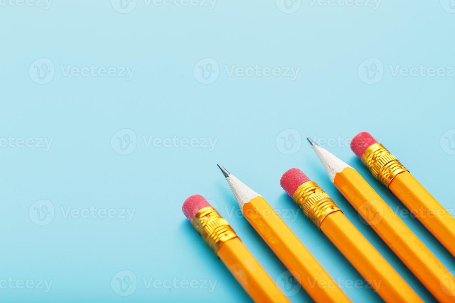 Orange pencils with an eraser on a blue background. photo