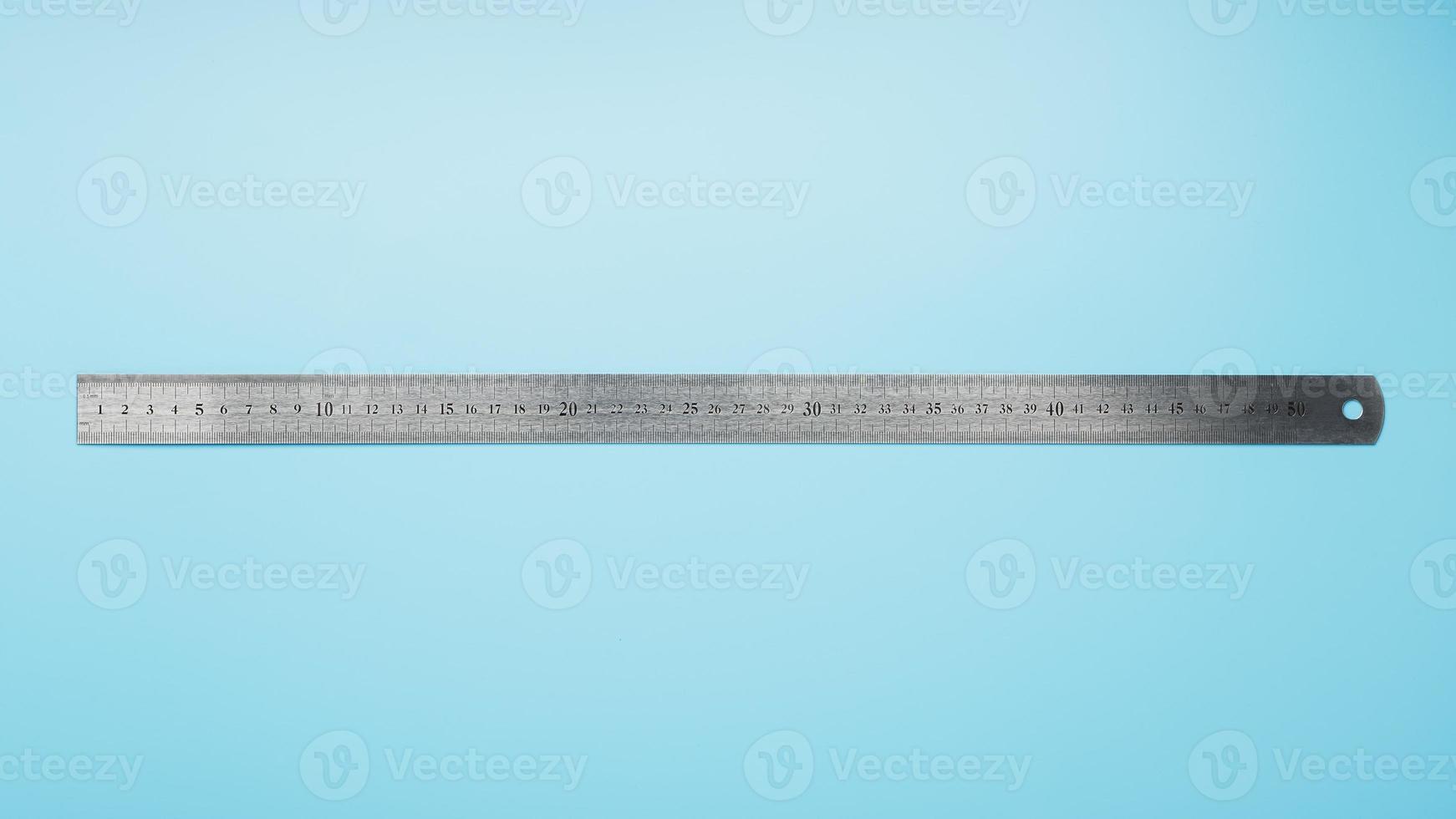 A metal ruler with a scale on a blue background is a superscape with a copy of the space for your text. photo