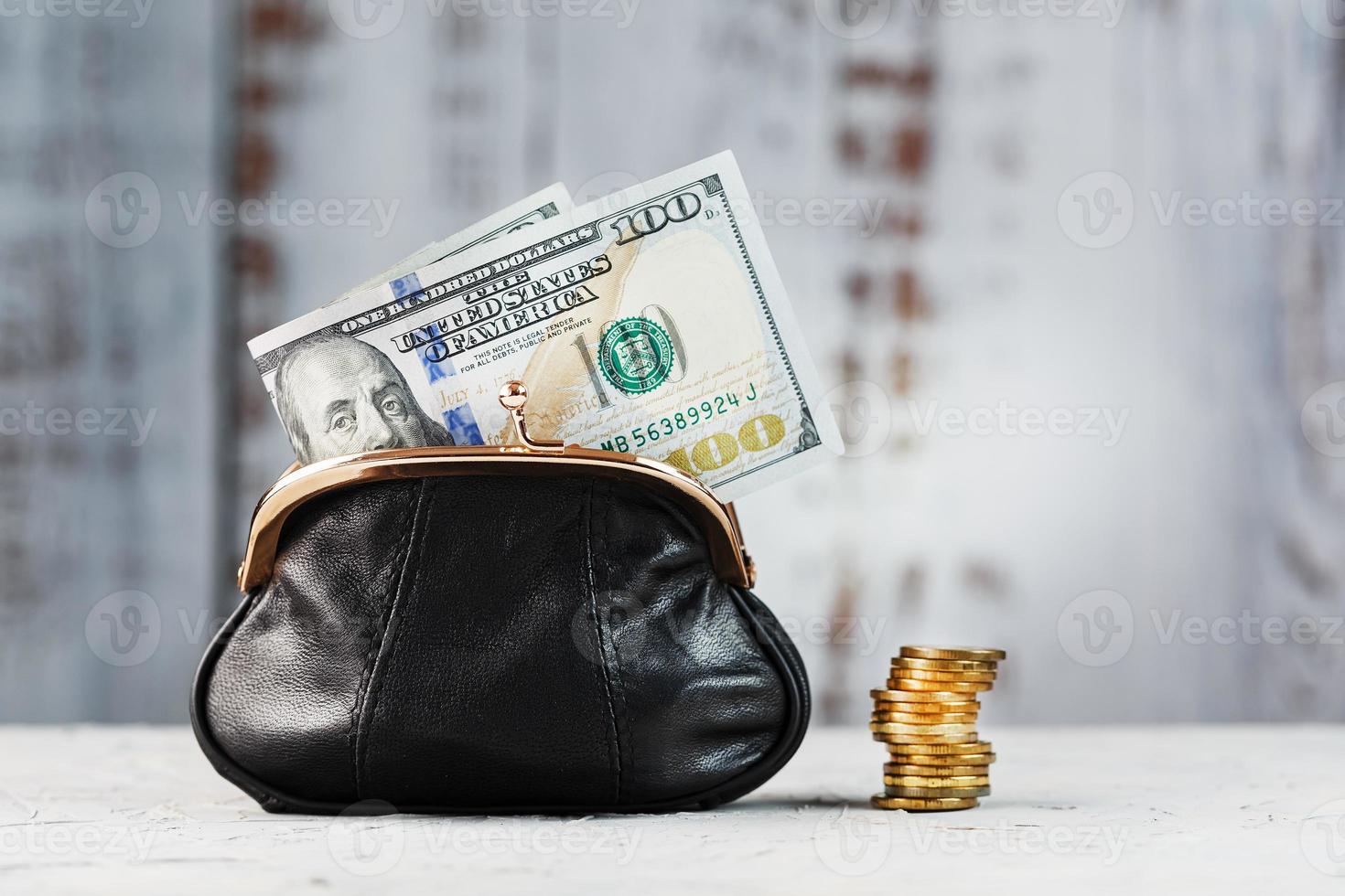 Wallet with gold coins and dollars on a gray background. Budget for investment in the future. photo