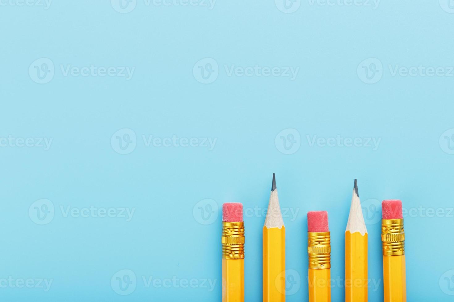 Orange pencils with an eraser on a blue background. photo