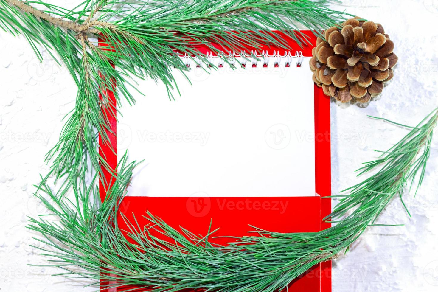 White paper blank for text with fir branch and brown cone on white snowy background. Christmas and New Year's picture. Business sheet. Red mailbox. Copy space photo