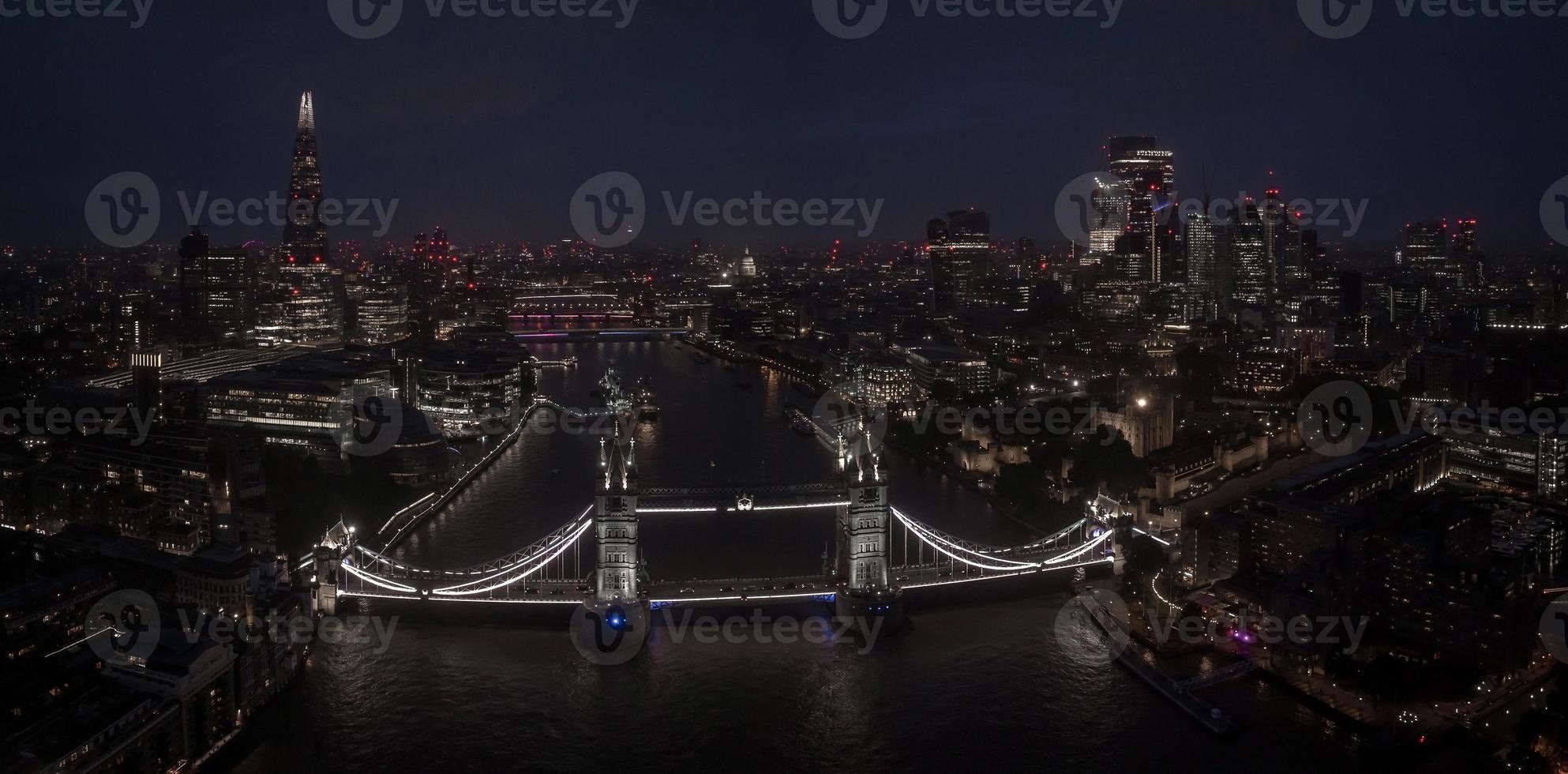Aerial view to the illuminated Tower Bridge and skyline of London, UK photo