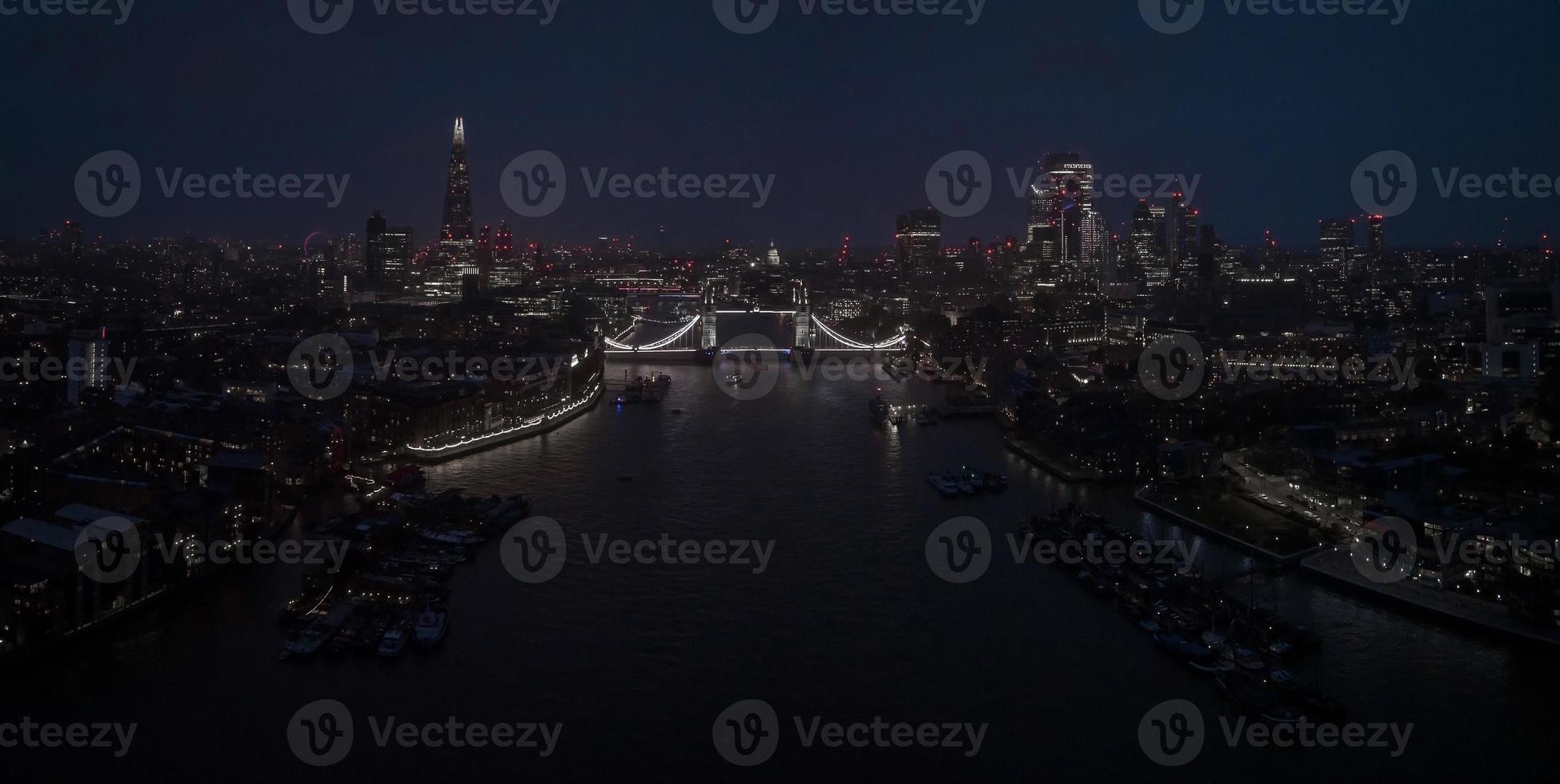 Aerial view to the illuminated Tower Bridge and skyline of London, UK photo