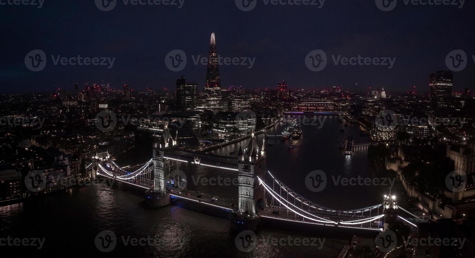 Aerial view to the illuminated Tower Bridge and skyline of London, UK photo