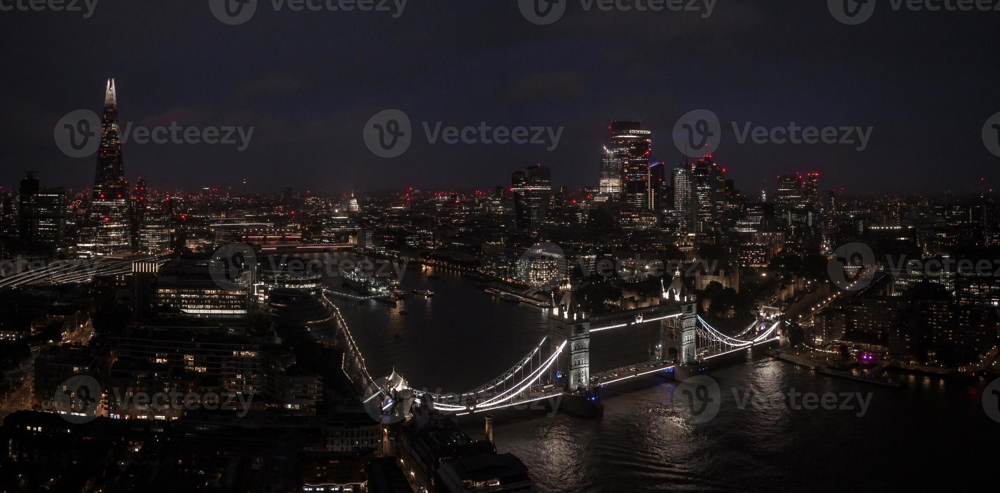 Aerial view to the illuminated Tower Bridge and skyline of London, UK photo