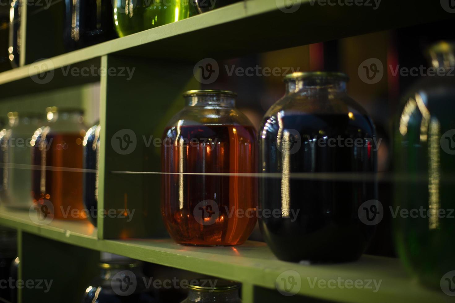 Cans on shelf with colored water. Interior details. Glass containers. photo