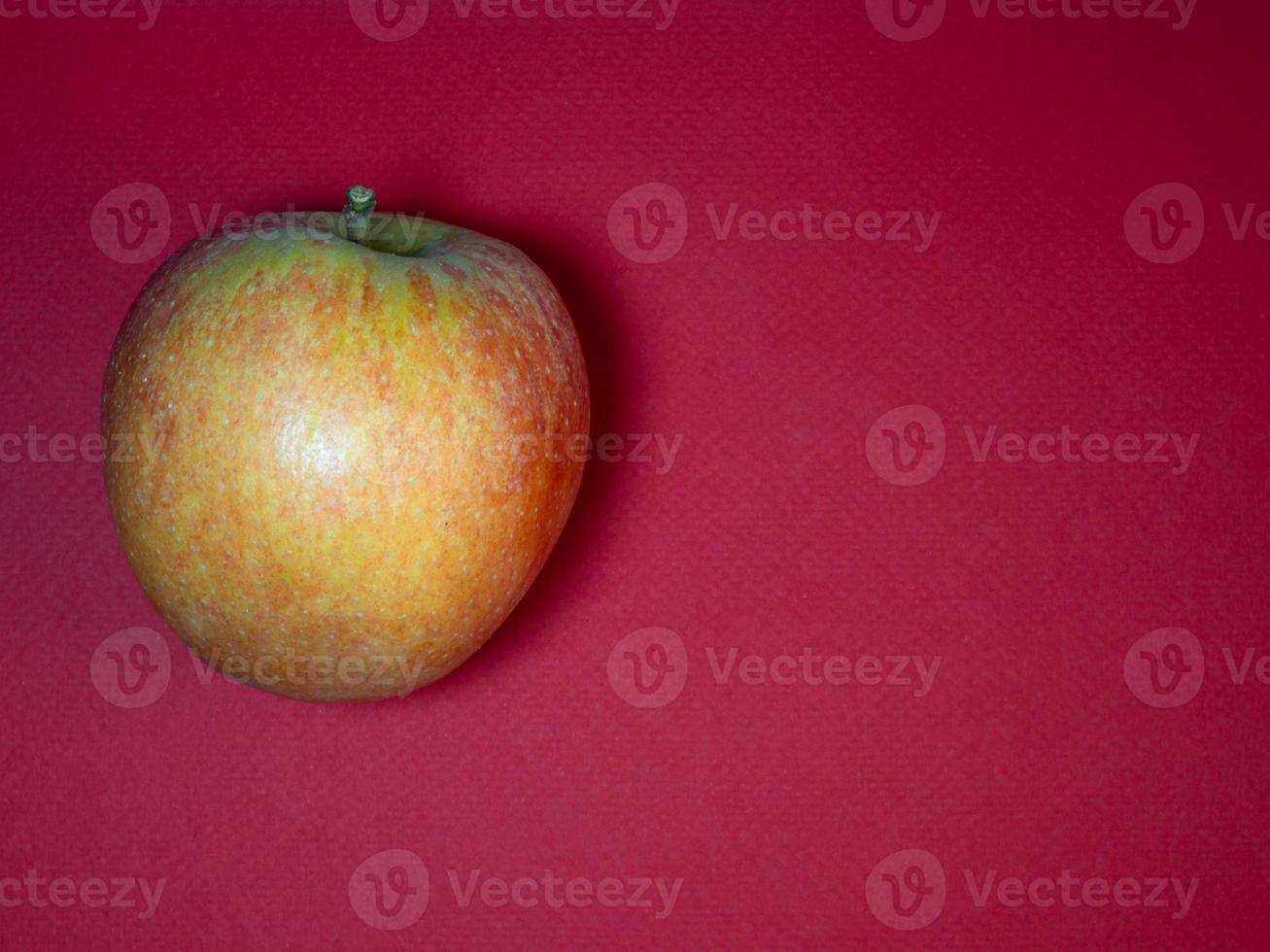 gran manzana roja sobre un fondo morado. el producto está sobre la mesa. frutas maduras frescas. foto