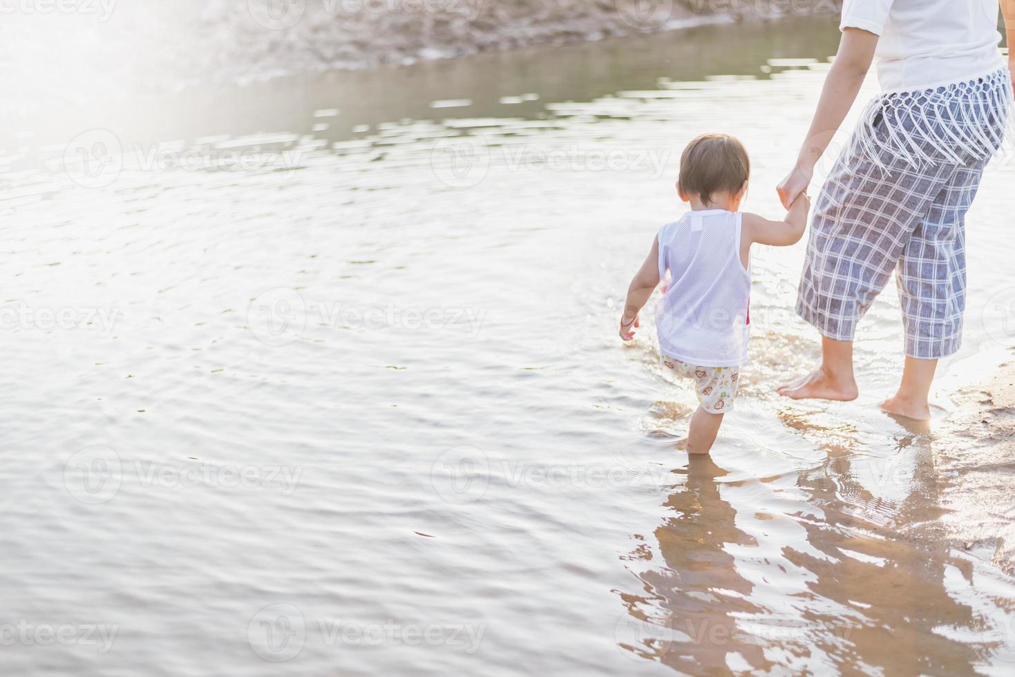 Mother and daughter enjoy playing in the lake. photo