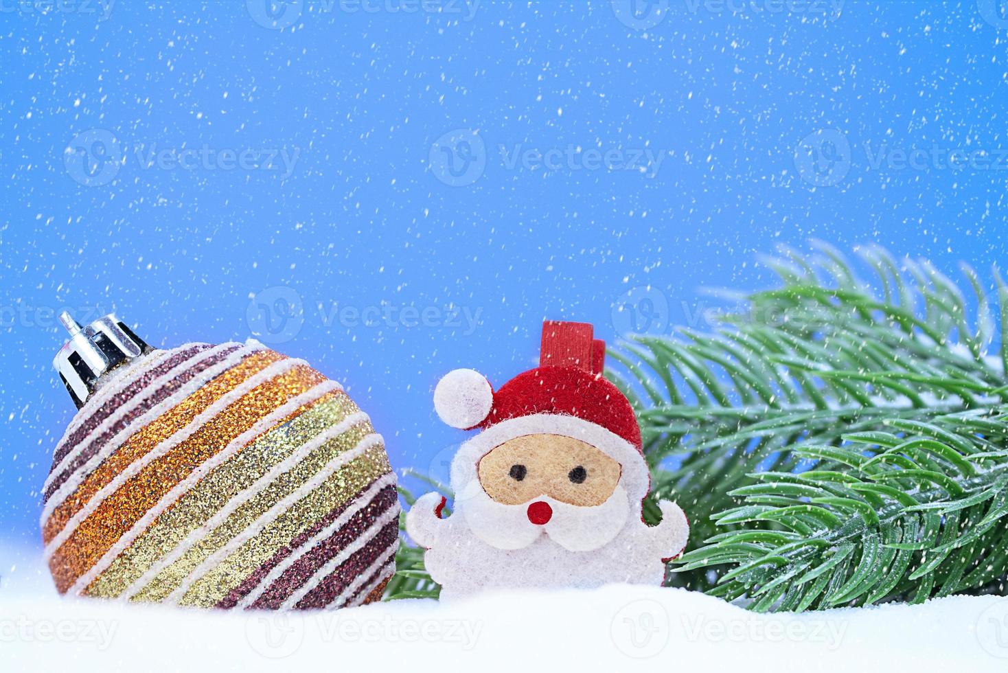 Christmas shiny striped ball with Santa Claus spruce branches on snow. Snowing. New Year. Copy space photo