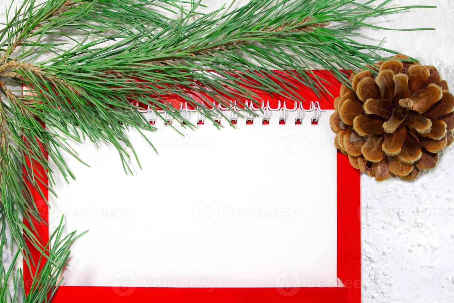 White paper blank for text with fir branch and brown cone on white snowy background. Christmas and New Year's picture. Business sheet. Copy space photo