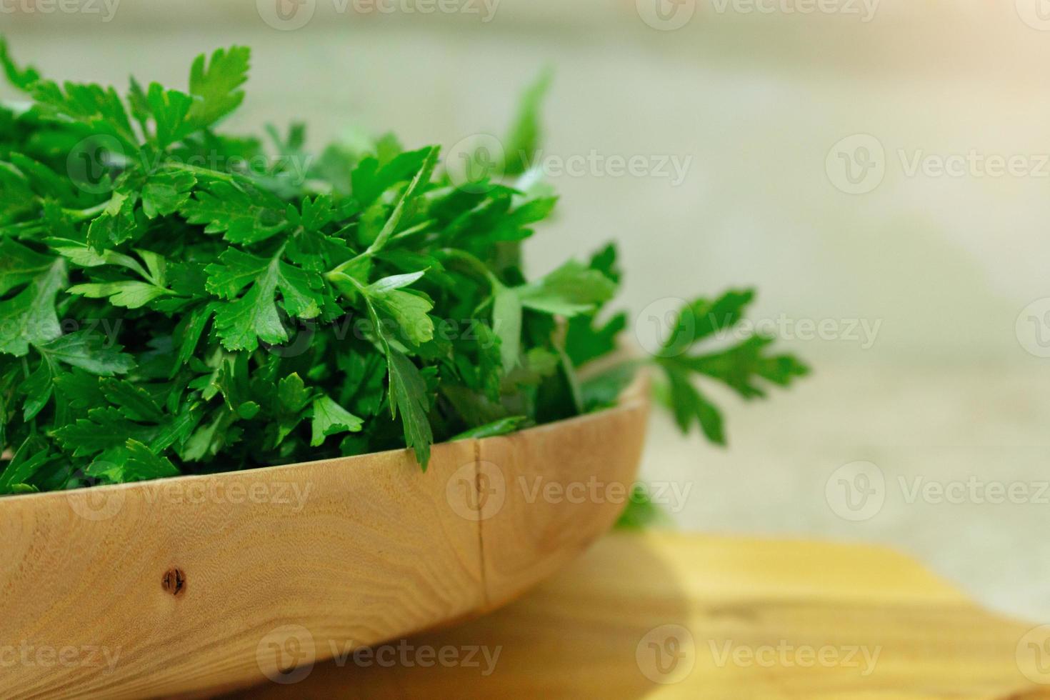 parsley, cilantro in a wooden plate on the table. Background soft focus. Ingredient for cooking photo