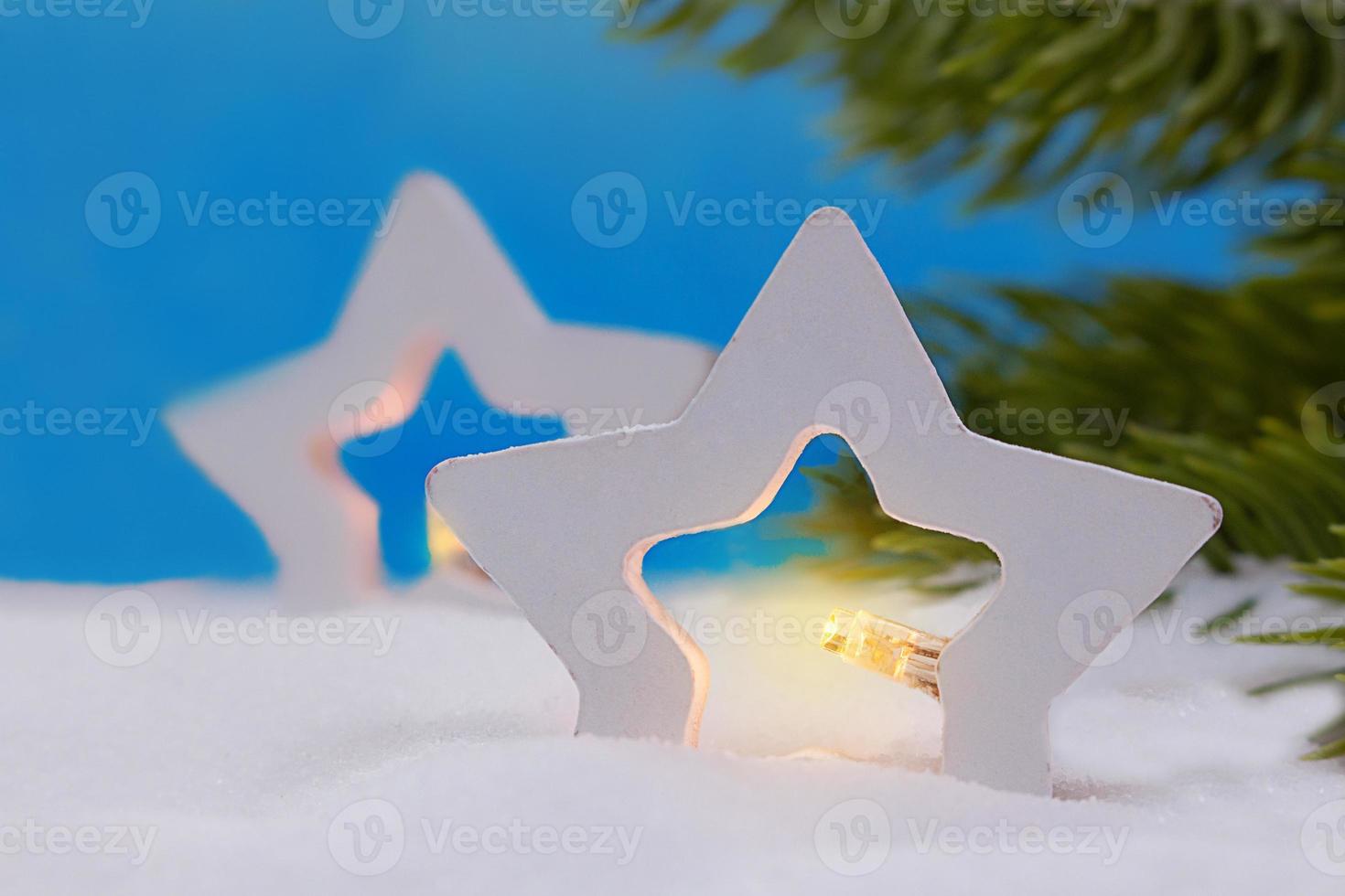 Two stars with lights in snow. Branches of Christmas tree. New Year. Copy space photo