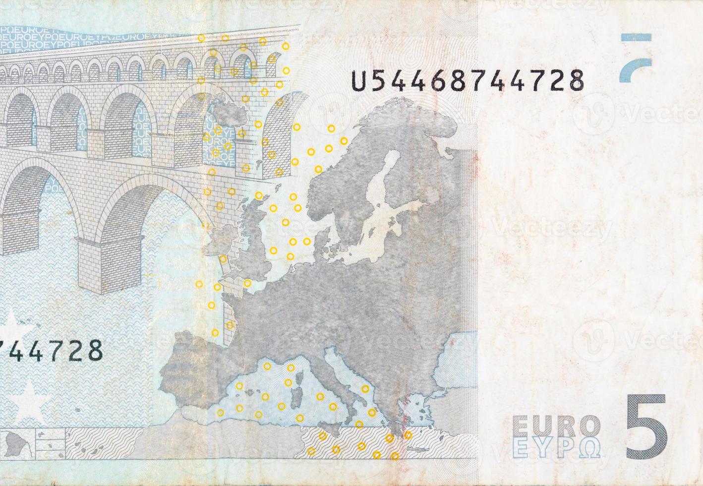 Fragment part of 5 euro banknote close-up with small brown details photo