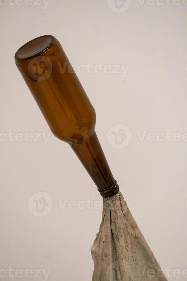 empty beer bottle on white background, with concrete towel under the bottle photo