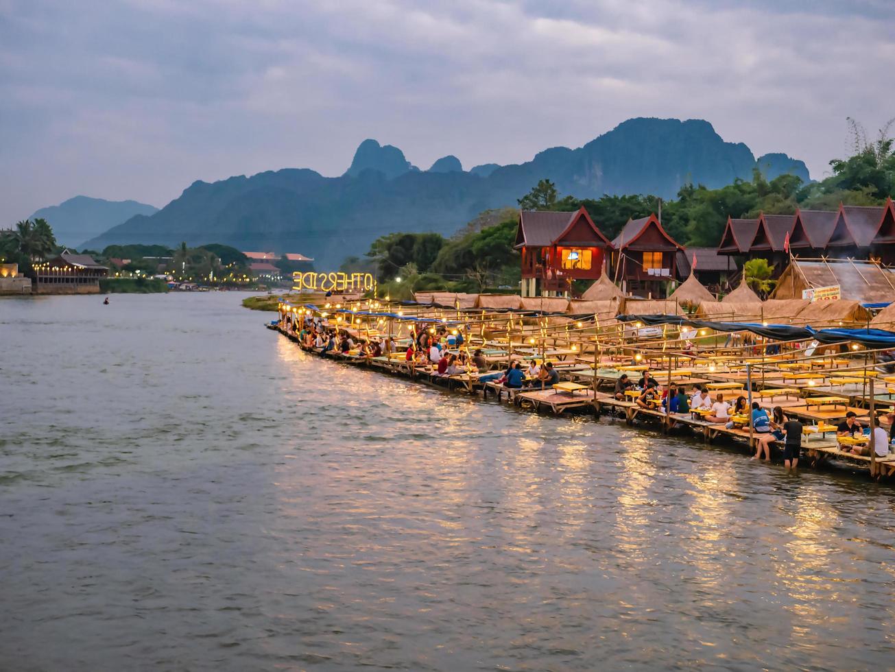 Vangvieng.lao-11 Dec 2017.Beautiful view of nam song river with Tourist on riverside restaurant and the mountain in the night at Vangvieng city Lao.Vangvieng City The famous holiday destination town photo