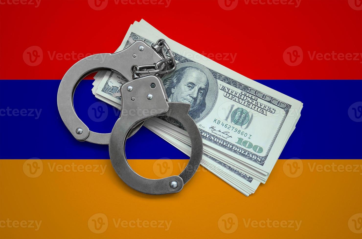 Armenia flag  with handcuffs and a bundle of dollars. Currency corruption in the country. Financial crimes photo