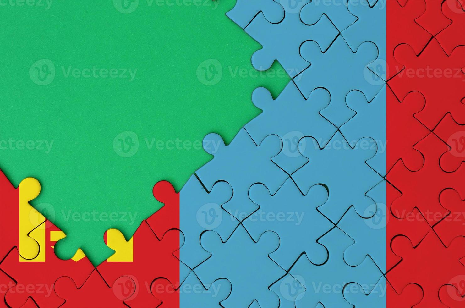 Mongolia flag  is depicted on a completed jigsaw puzzle with free green copy space on the left side photo