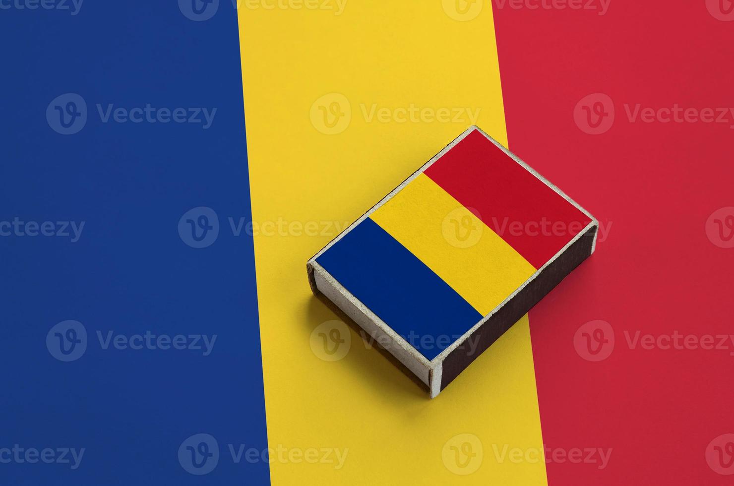 la bandera de rumania está representada en una caja de fósforos que se encuentra en una bandera grande foto