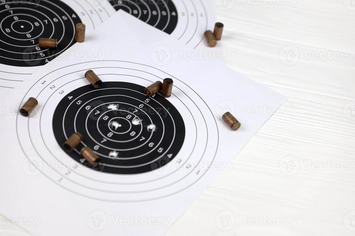 Many bullets on shooting targets on white table in shooting range polygon. Training for aiming and shooting photo