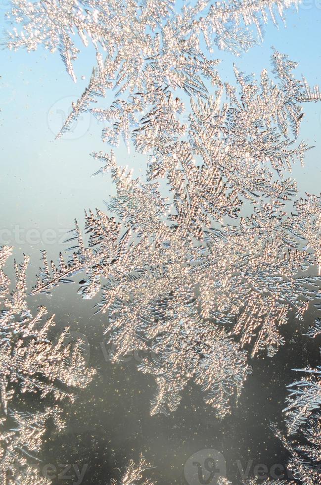 Snowflakes frost rime macro on window glass pane photo